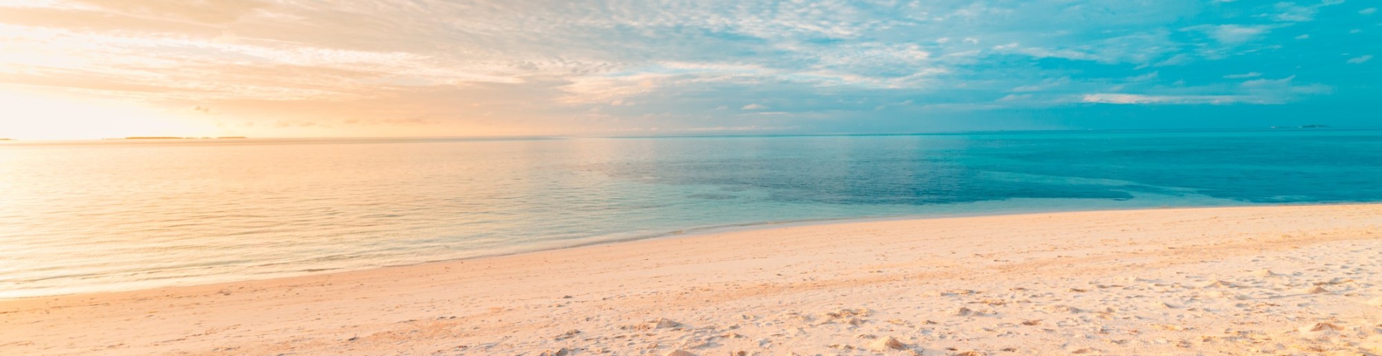 A serene white sand beach under a bright sky